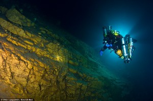 A frogman glides through a crystal blue lagoon beneath a