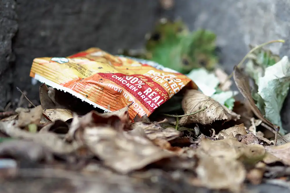 Discarded plastic food packaging, including crisp packets and sweet wrappers,
