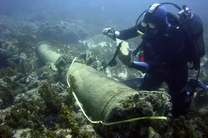 a scuba diver prepares to raise a cannon from a