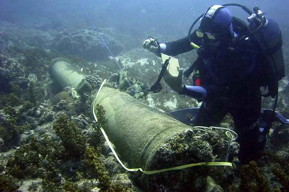 a scuba diver prepares to raise a cannon from a
