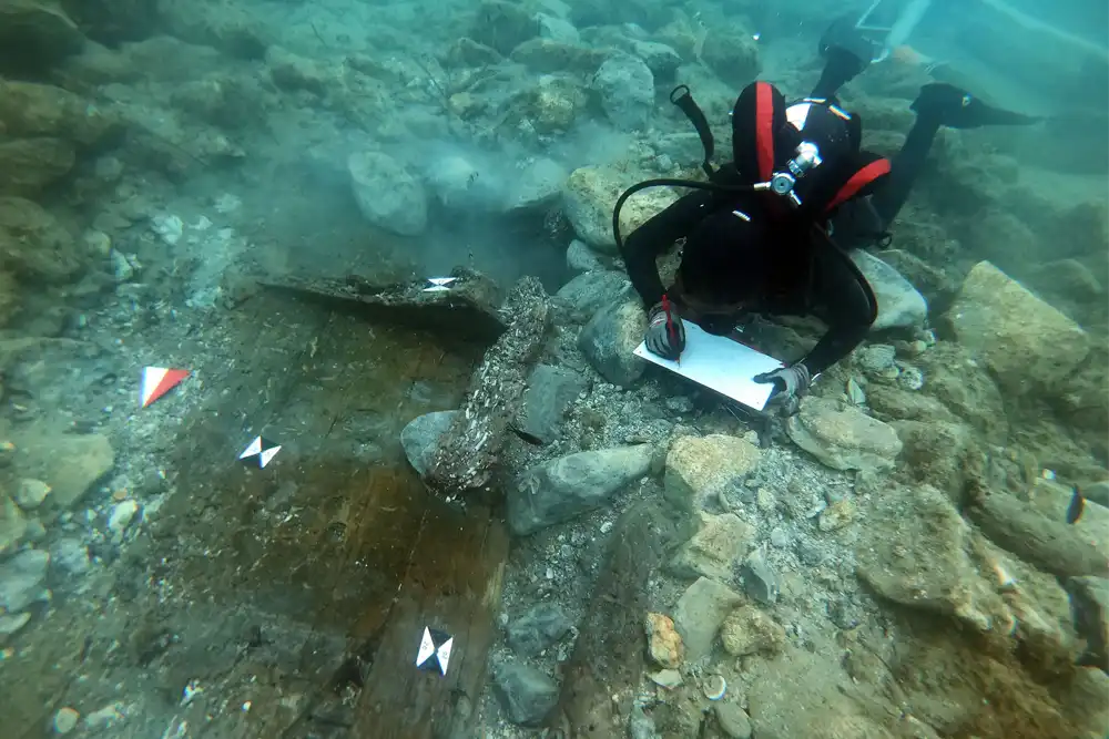 A diver inspects the ancient wreck of the coast of